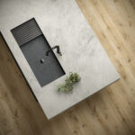 black farmhouse sink in stone island kitchen